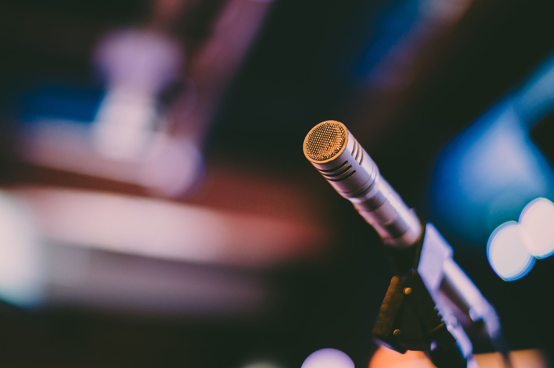 Sửa Micro Không Dây Bị Rè, Mất Sóng - Detailed shot of a microphone with artistic bokeh background, ideal for concerts.