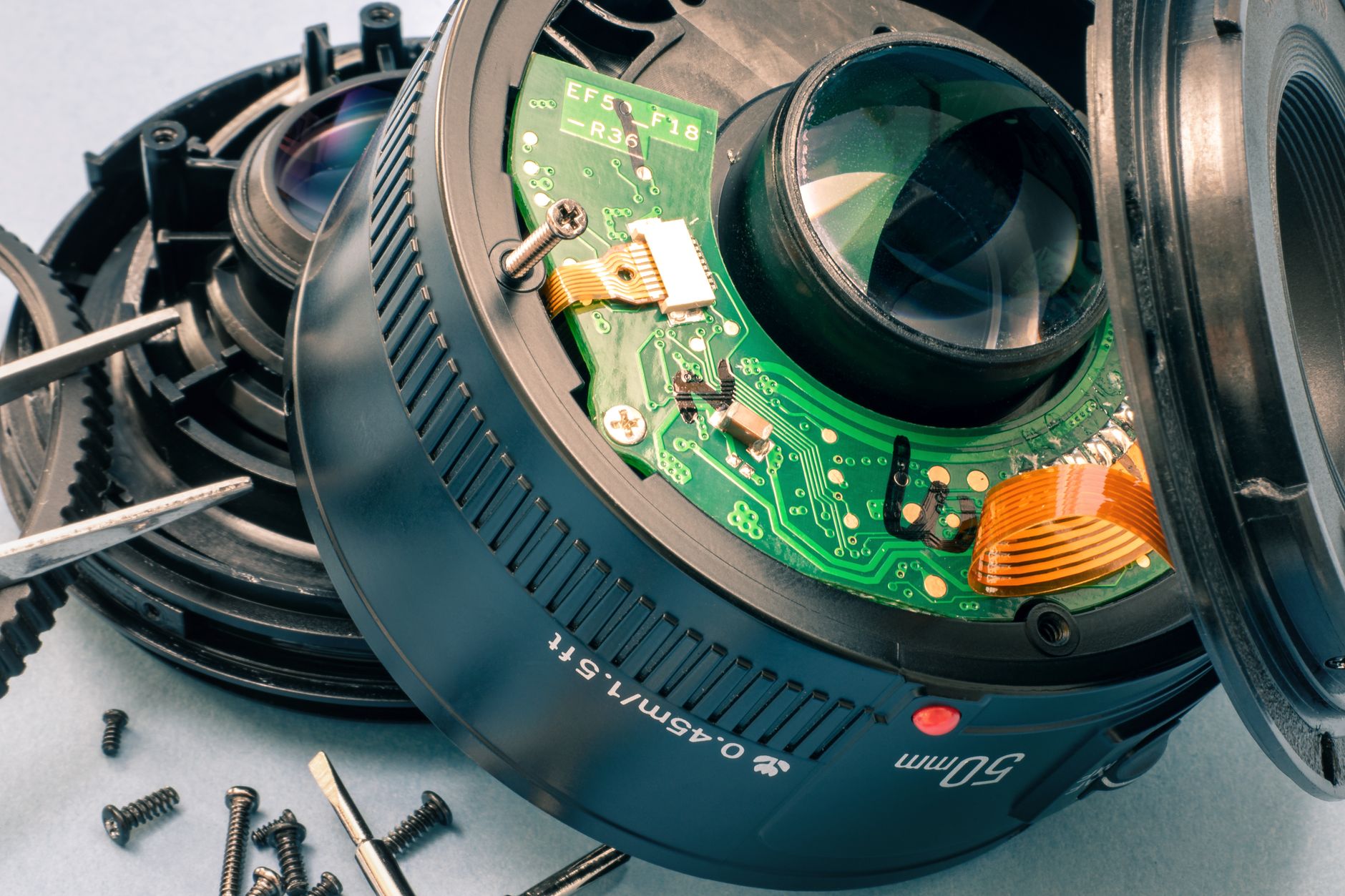 Stereo, Mono, Surround là gì - Detailed macro of a disassembled camera lens showing internal circuitry and components.