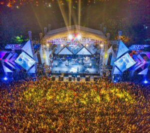 Âm thanh sân khấu ngoài trời cần gì - Aerial view of a large crowd enjoying a nighttime concert.