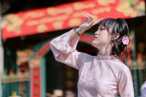 amply bị phù tụ - Portrait of a young woman wearing traditional dress with floral accessory, outdoors.