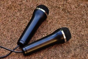 Amply Là Gì? Cấu Tạo & Nguyên Lý Hoạt Động Chi Tiết, amply là gì - Close-up of two black handheld microphones on a textured background, perfect for audio themes.