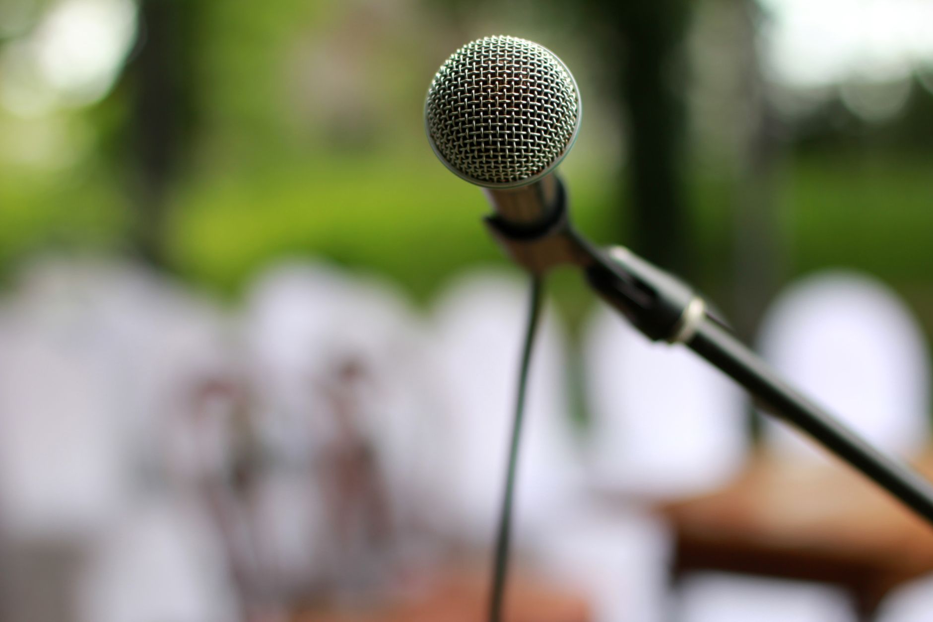 Micro Có Dây Bị Đứt Tiếng, Chập Chờn - Focused view of a microphone on a stand outdoors, ready for a performance.