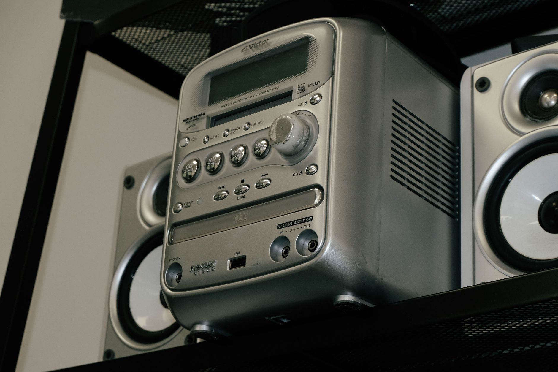 Cách Bảo Quản & Vệ Sinh Loa Để Bền Lâu - A classic silver stereo system with speakers on a shelf, showcasing retro design.
