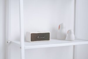 Cách Bảo Quản & Vệ Sinh Loa Để Bền Lâu - A stylish setup featuring a Marshall wireless speaker and minimalist decor on a white shelf.