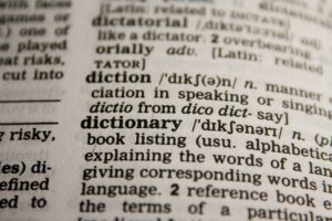 Cách Sử Dụng Amply Đúng Cách Để Bền & Hay - Detailed close-up view of a dictionary page highlighting the word 'dictionary' and its definition.