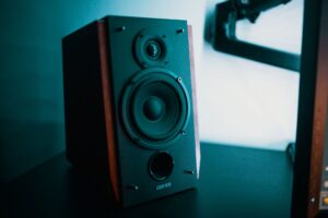 cách treo loa lên tường đúng kỹ thuật - Contemporary style music speaker with round diffuser and dust cap on dark desk in flat