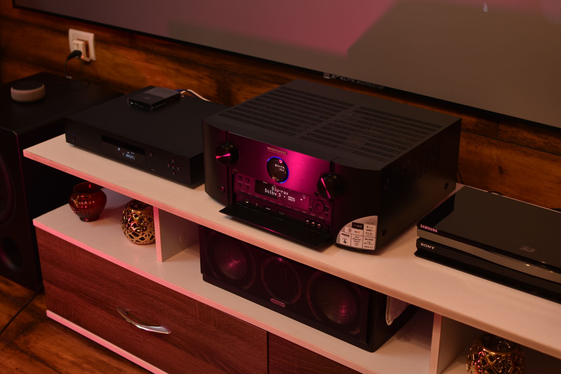 Cách Chọn Amply Phù Hợp Với Loa Karaoke (Theo Công Suất) - A sophisticated home theater setup featuring a modern amplifier surrounded by speakers, ideal for electrifying music experiences.