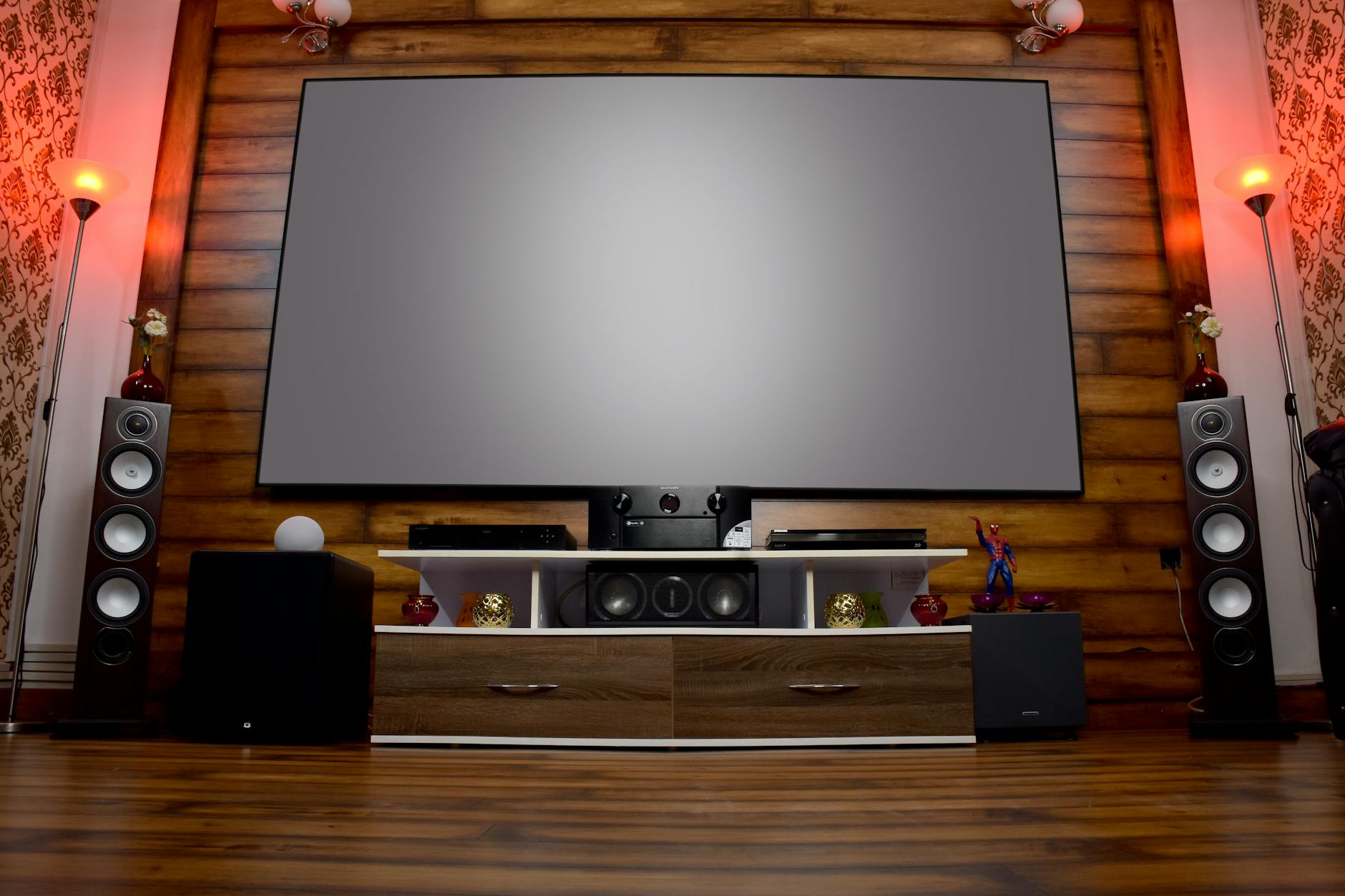 cách treo loa lên tường đúng kỹ thuật - Stylish home theater featuring large screen, audio system, and decor, perfect for entertainment.