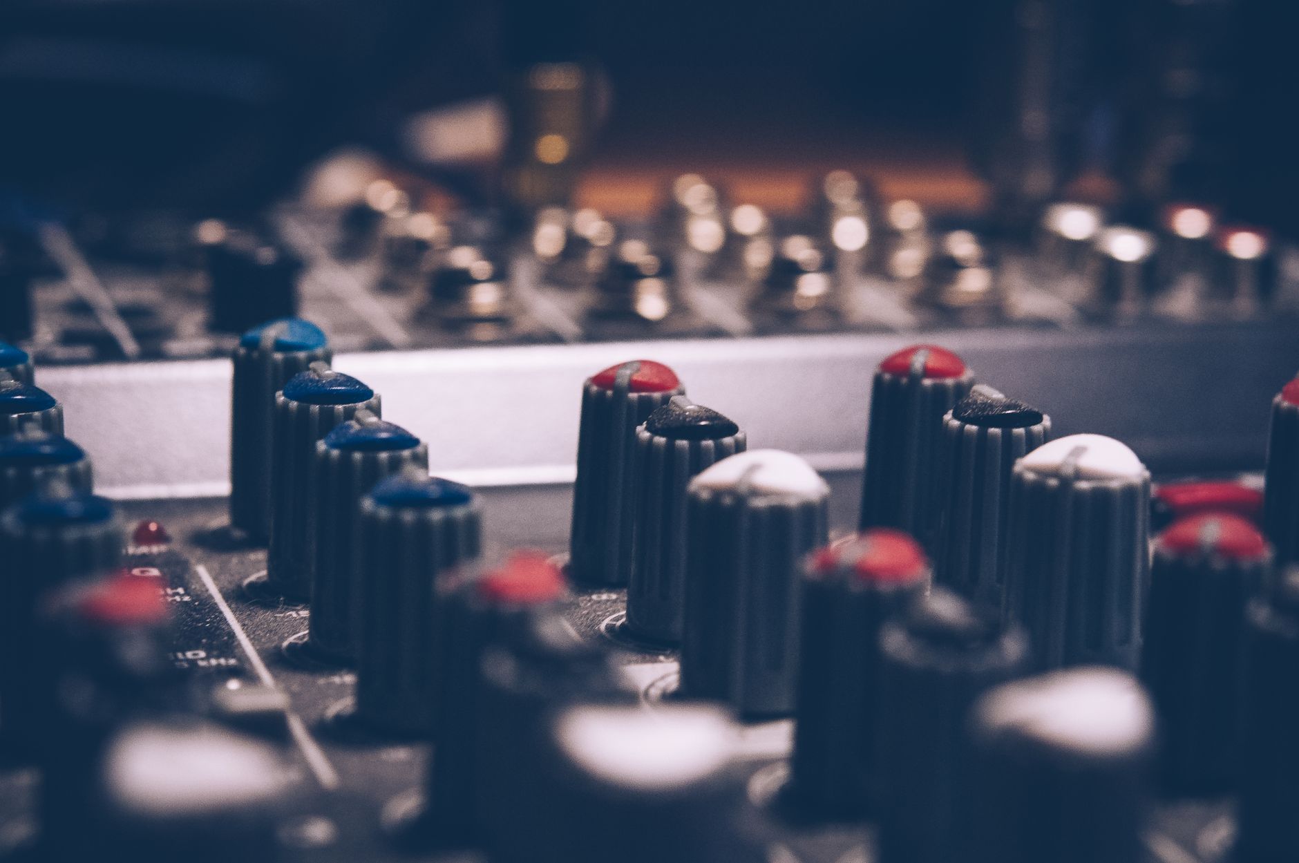 Sửa Amply California – Lỗi Phổ Biến & Cách Xử Lý - Close-up of audio mixer knobs in a dimly lit studio. Perfect for music and technology themes.
