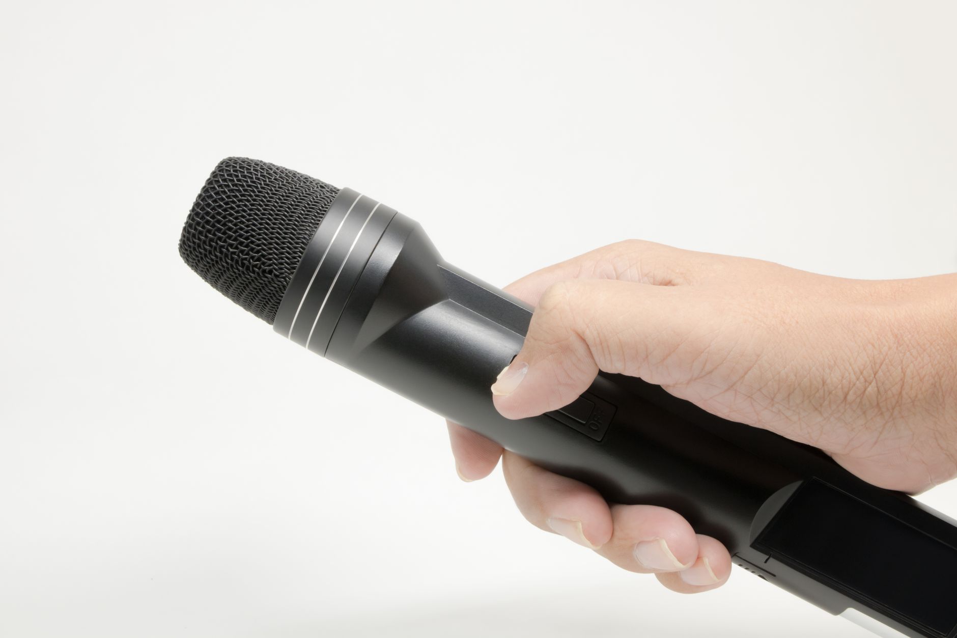 Cách Thay Côn Loa (Voice Coil) Bị Cháy - Detailed image of a hand gripping a black microphone, isolated on white.