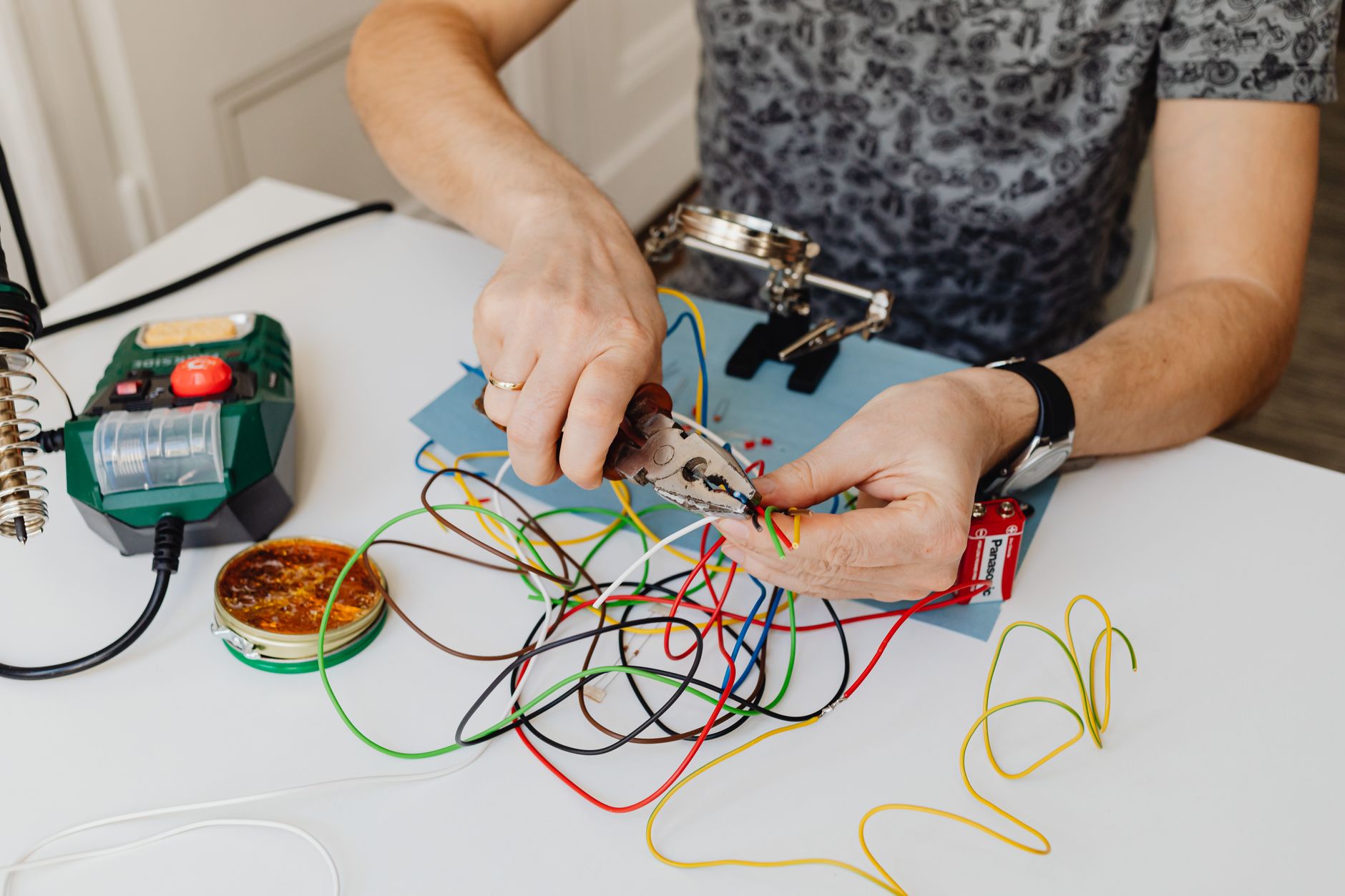 Dây tín hiệu (canon/XLR, jack 6 ly) khác nhau thế nào - A technician precisely cuts and organizes colorful wires using pliers, showcasing expertise in wiring tasks.