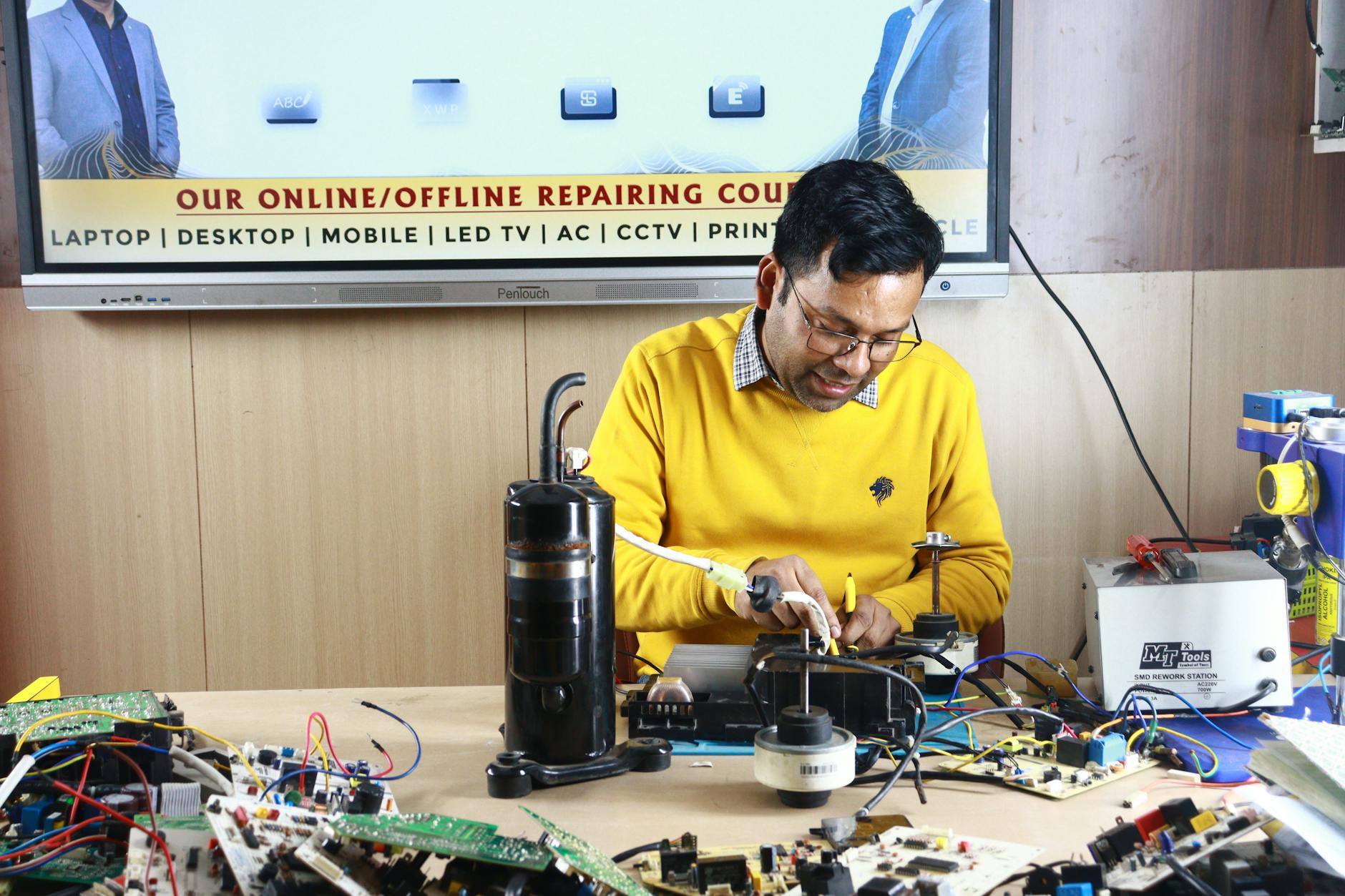 Ổn áp/lọc nguồn cho dàn âm thanh có cần không - Technician engaged in AC repair at a New Delhi workshop. Indoor learning session.