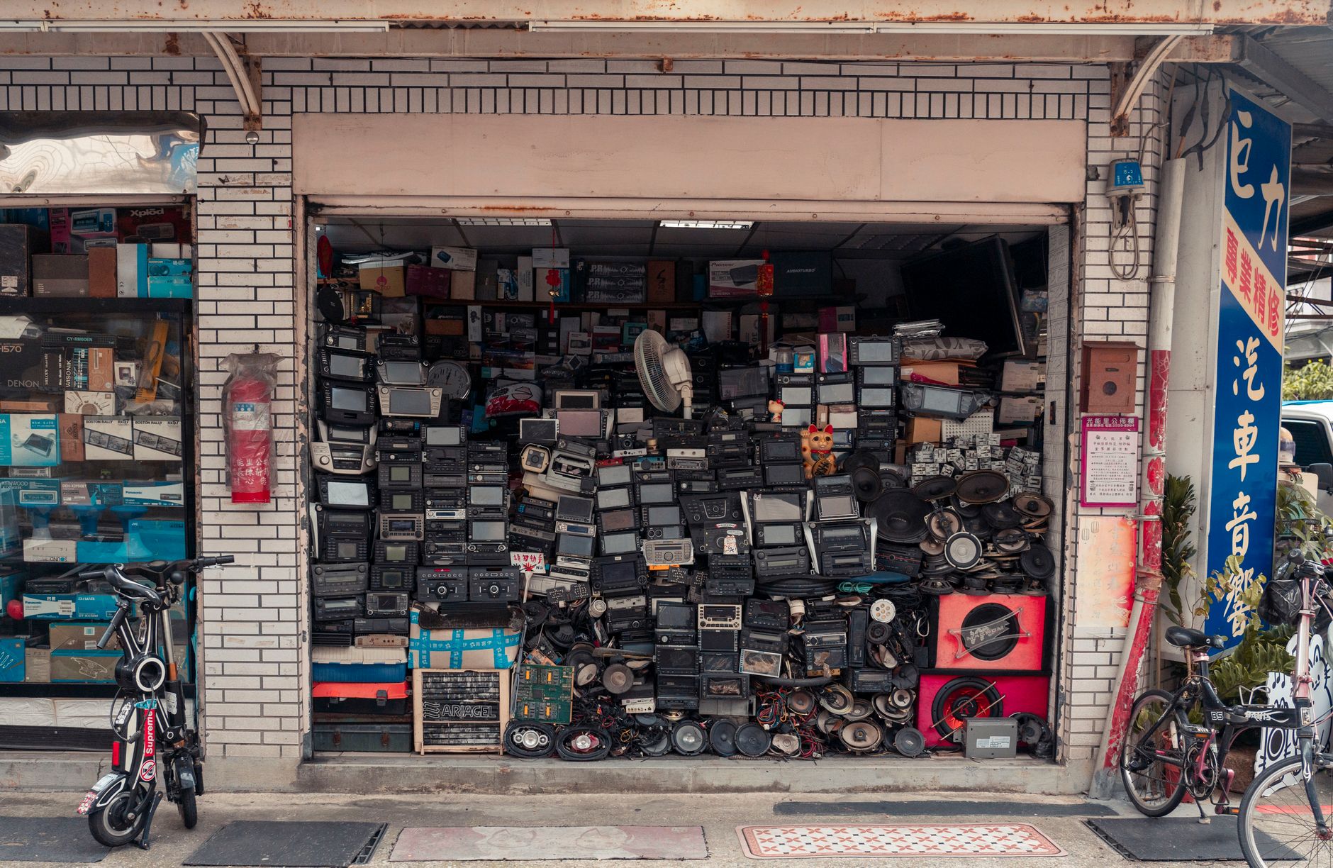 Stereo, Mono, Surround là gì - A cluttered street shop displaying vintage radios and electronics, creating a nostalgic urban scene.