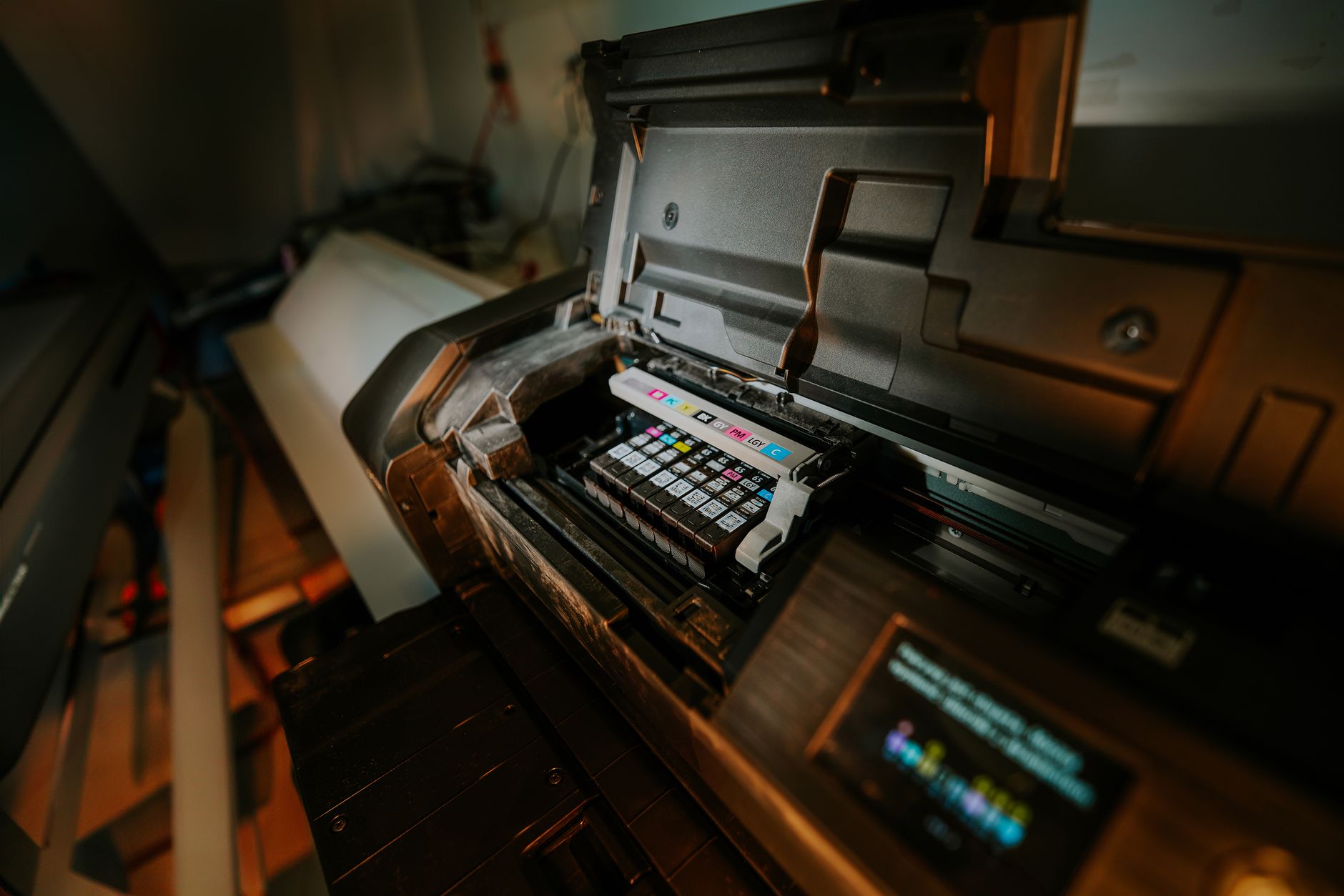 Thay Sò Công Suất Amply – Quy Trình & Chi Phí - Close-up view of an inkjet printer with exposed cartridges in a workspace setting.