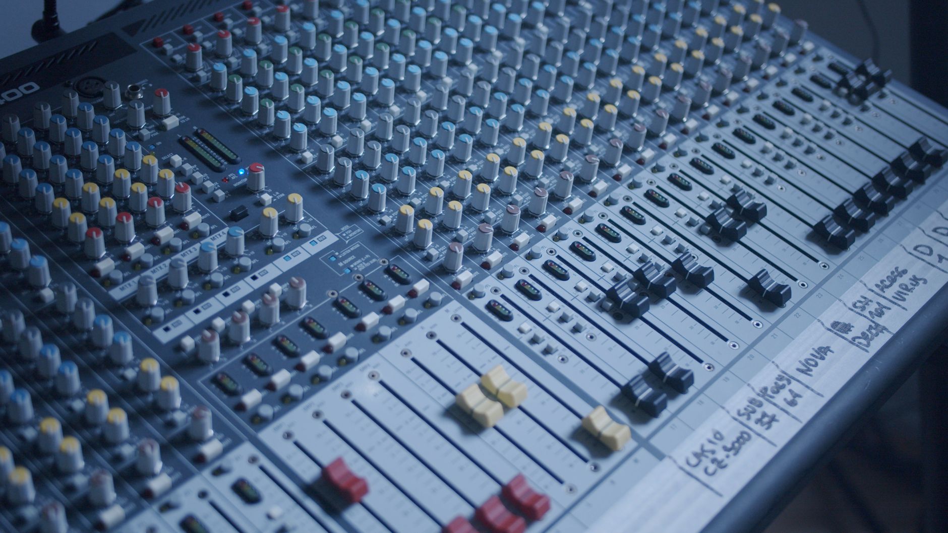 Âm thanh Analog vs Digital khác nhau thế nào - Detailed view of a professional audio mixer in a recording studio setting.