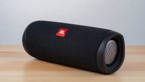 Loa Full, Loa Sub, Loa Bass Khác Nhau Thế Nào? - Close-up of a modern wireless speaker on a wooden table, highlighting sleek design.