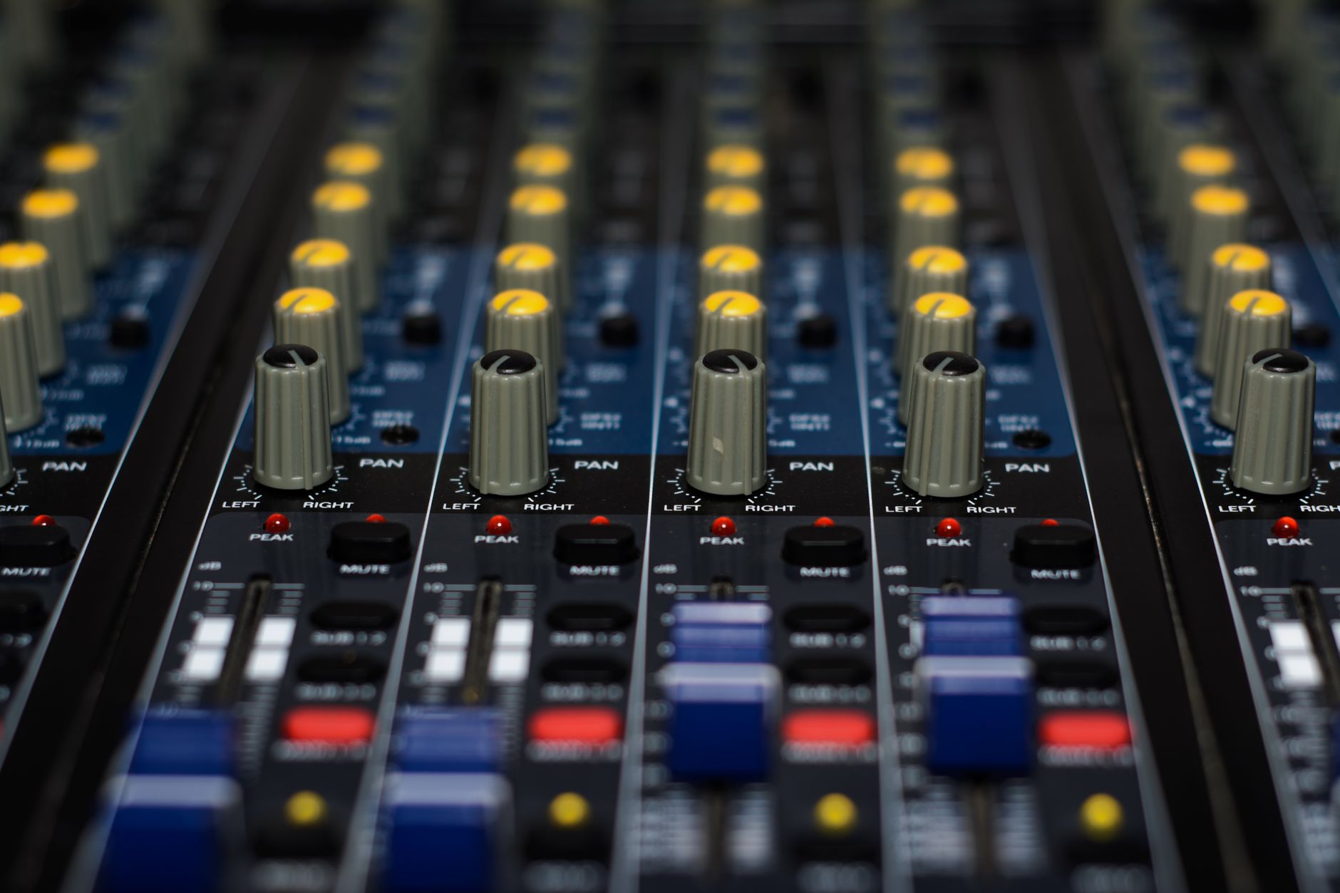 Âm thanh sân khấu ngoài trời cần gì - Detailed close-up of audio mixer knobs and buttons used in music production.