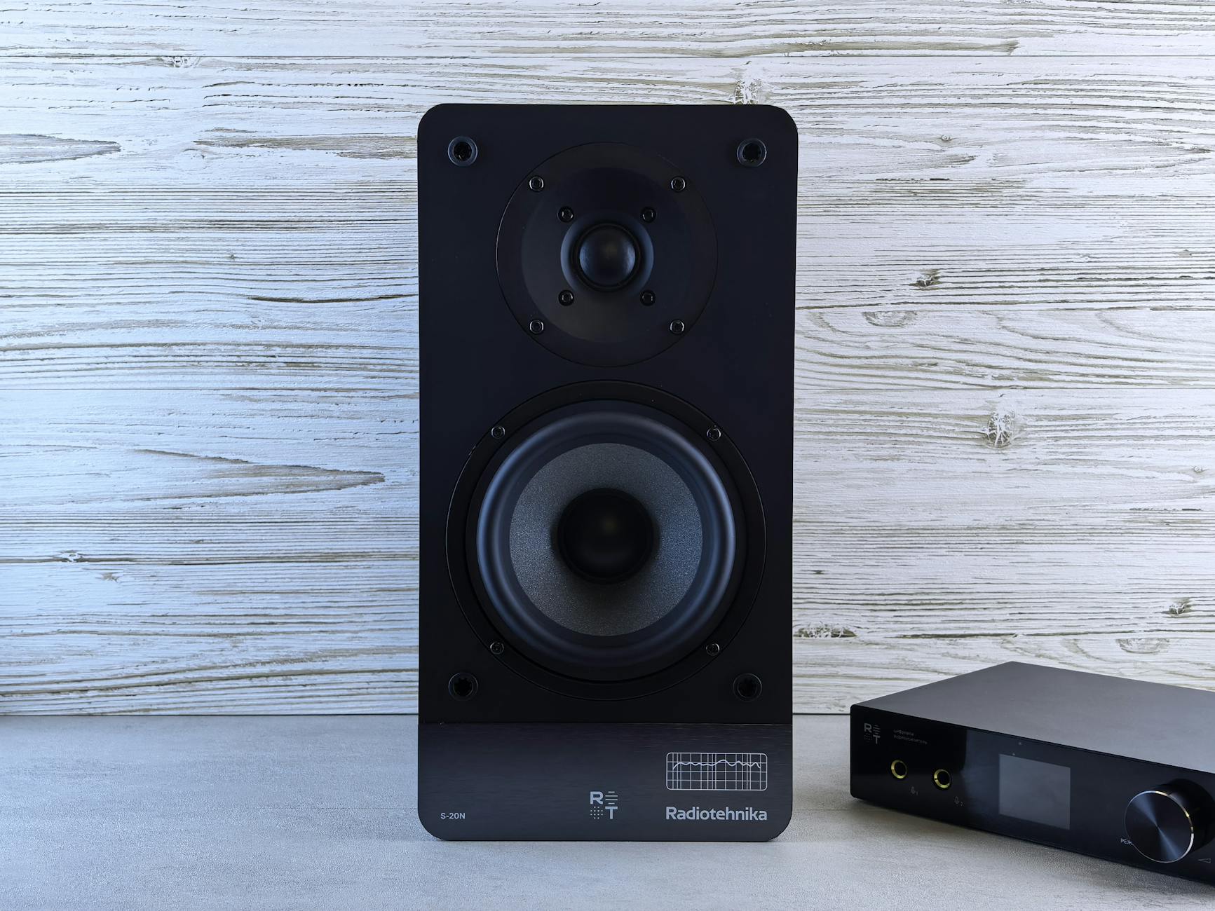Hướng Dẫn Phối Ghép Amply Với Loa Đúng Trở Kháng - High-quality black loudspeaker and amplifier on a wood background, perfect for audio setups.