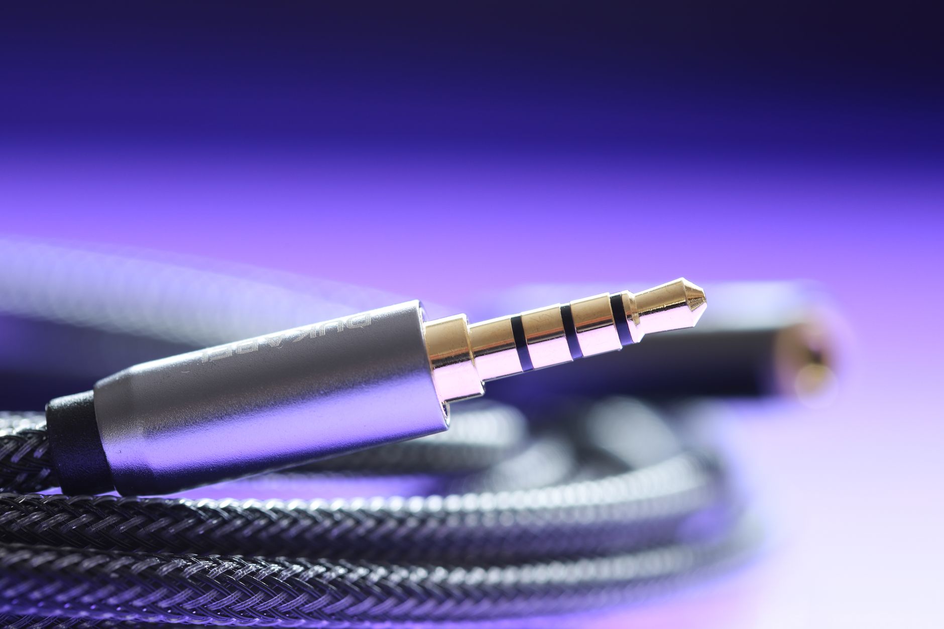 Cách chọn jack, đầu nối âm thanh - Detailed macro image of a 3.5mm audio jack cable with a braided wire.