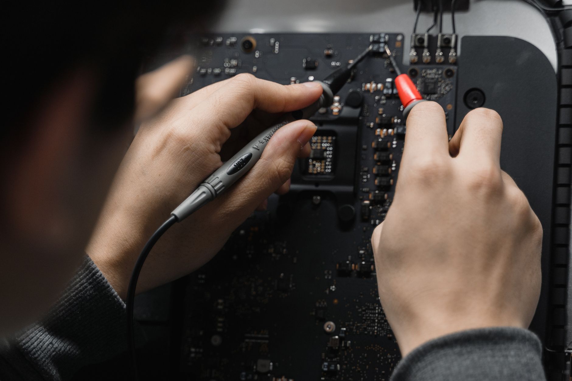 sửa mạch echo amply - Close-up of hands repairing a circuit board using a soldering iron, emphasizing technical skill.