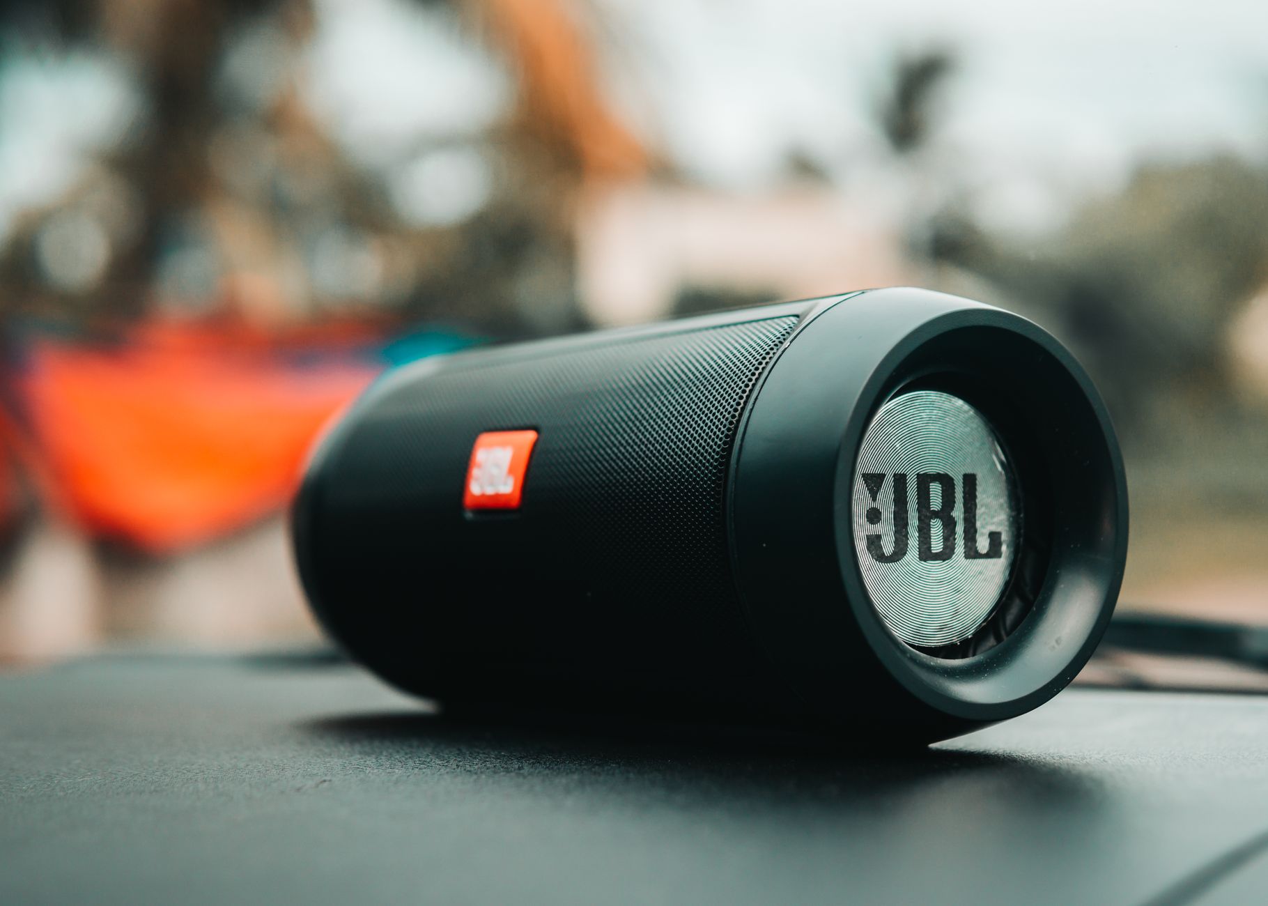 Thay Gân Loa (Viền Nhún) – Bệnh Loa Cũ Thường Gặp - Focused shot of a black JBL portable speaker on a surface, ideal for technology concepts.