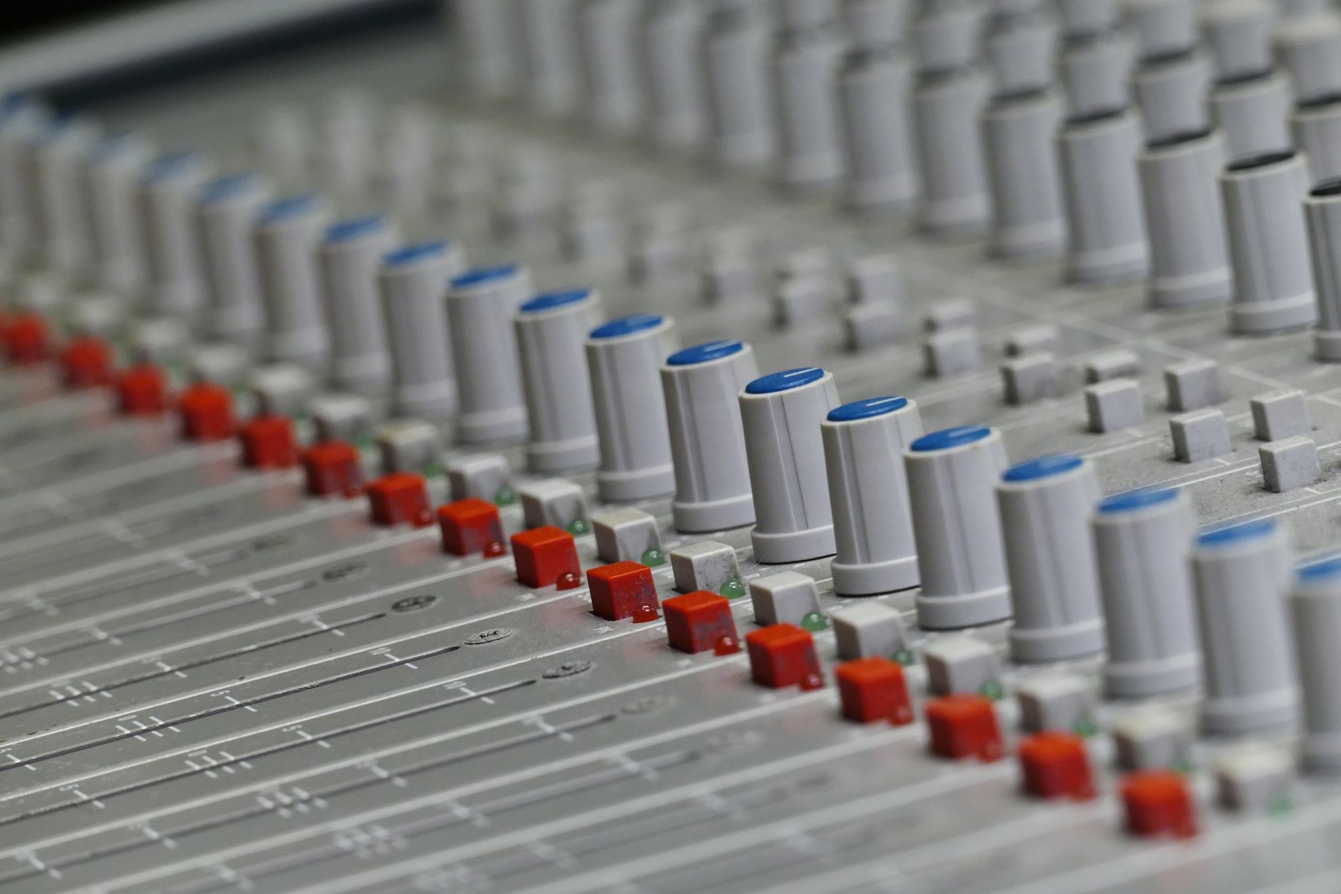 Âm thanh Analog vs Digital khác nhau thế nào - Close-up of an audio control panel featuring knobs and sliders for sound mixing.