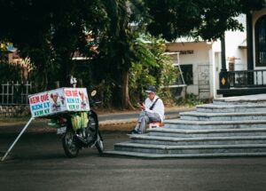 Sửa Amply California – Lỗi Phổ Biến & Cách Xử Lý - Ice cream vendor sitting by cart on a street in Kon Tum, Vietnam.